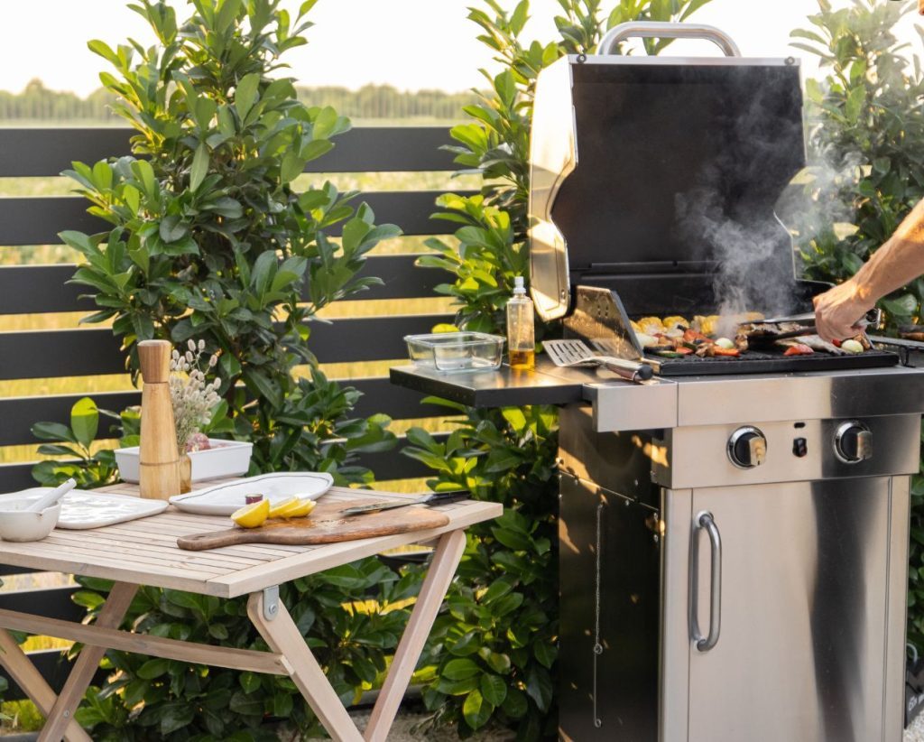 photo d'un barbecue sur une terrasse manié par un homme