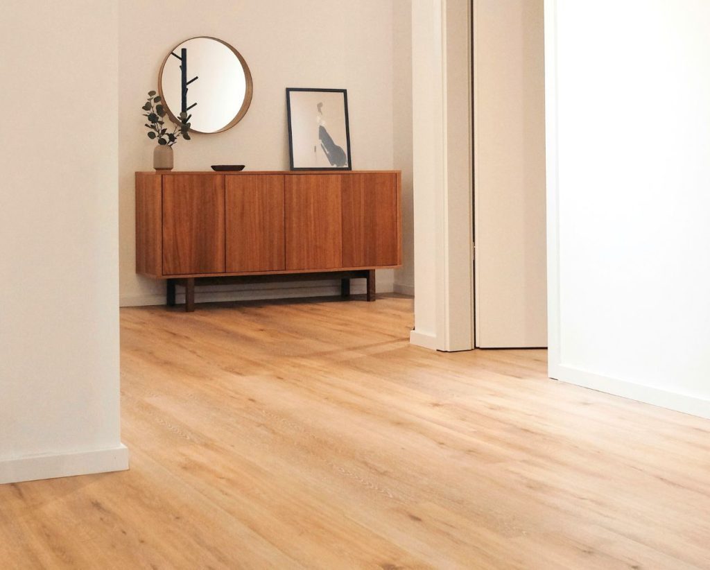 Photo d'un grand salon avec un parquet et un meuble d'appoint